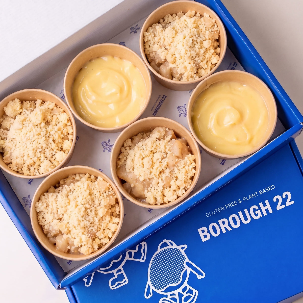Open Borough 22 box of six gluten free vegan dessert pots, four apple crumble pots and two vanilla custard pots in kraft tubs