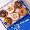 Open Borough 22 box of six gluten free vegan baked doughnuts, chocolate and vanilla iced with rainbow sprinkles, s'mores with toasted marshmallow, strawberry glazed and cinnamon sugar
