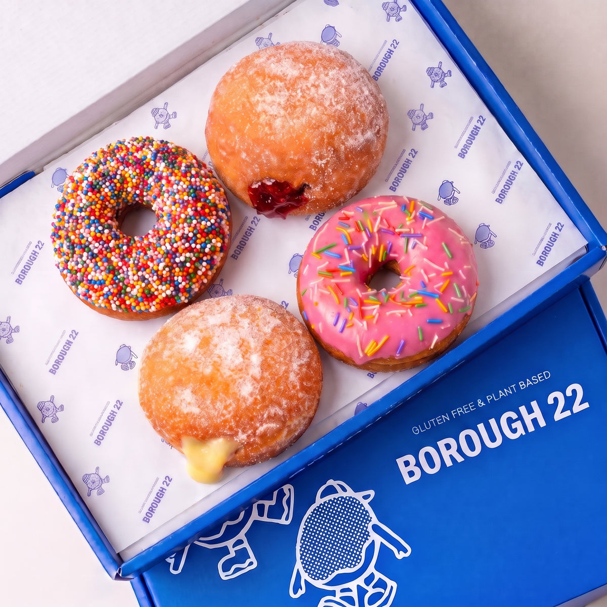 Gluten free vegan Little Celebration Box with a hundreds and thousands Dot, jam filled, custard filled and pink strawberry sprinkles doughnut