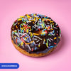 Gluten free vegan fried chocolate ring doughnut covered in rainbow sprinkles