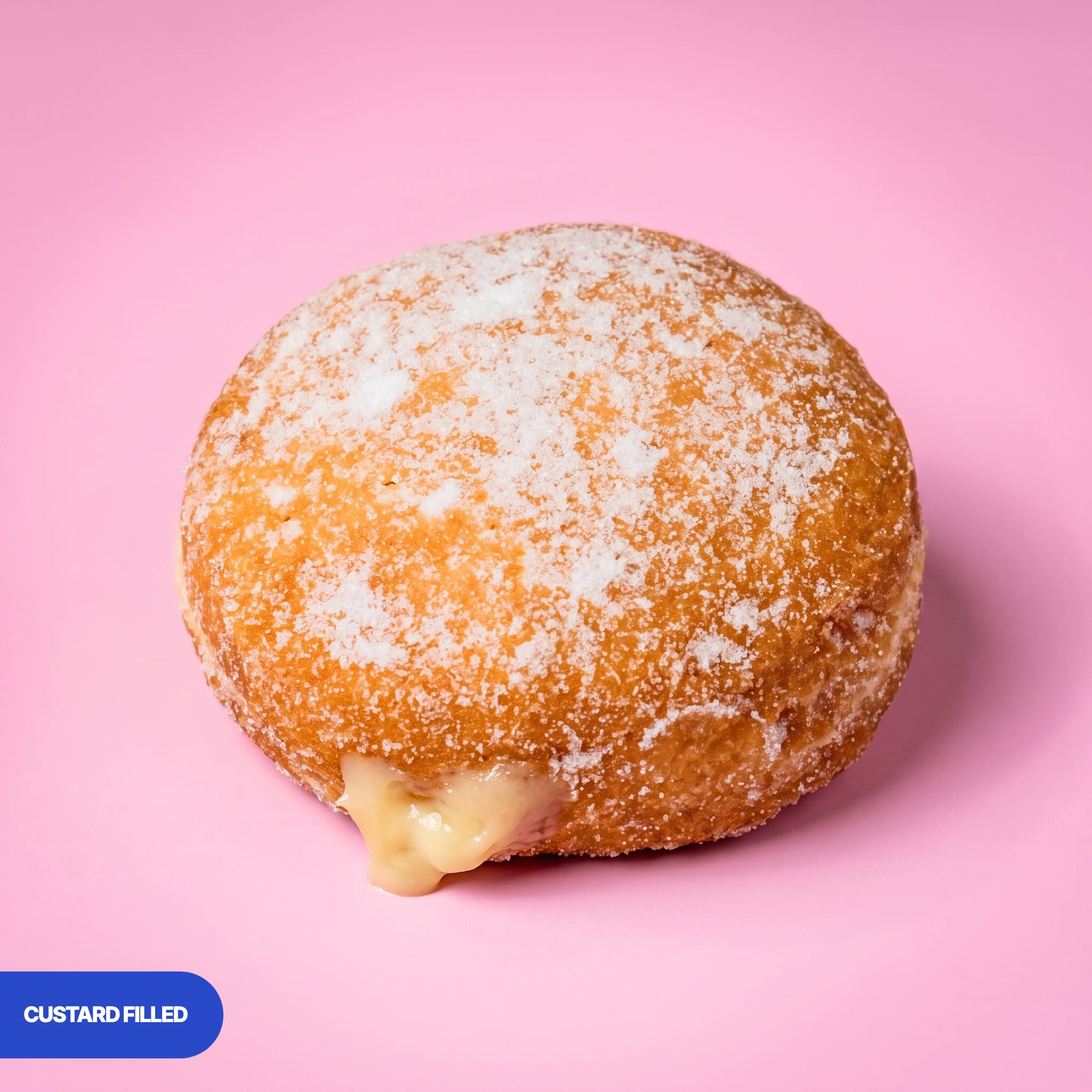 Gluten free vegan fried sugared doughnut filled with vanilla custard, the filling visible at the side