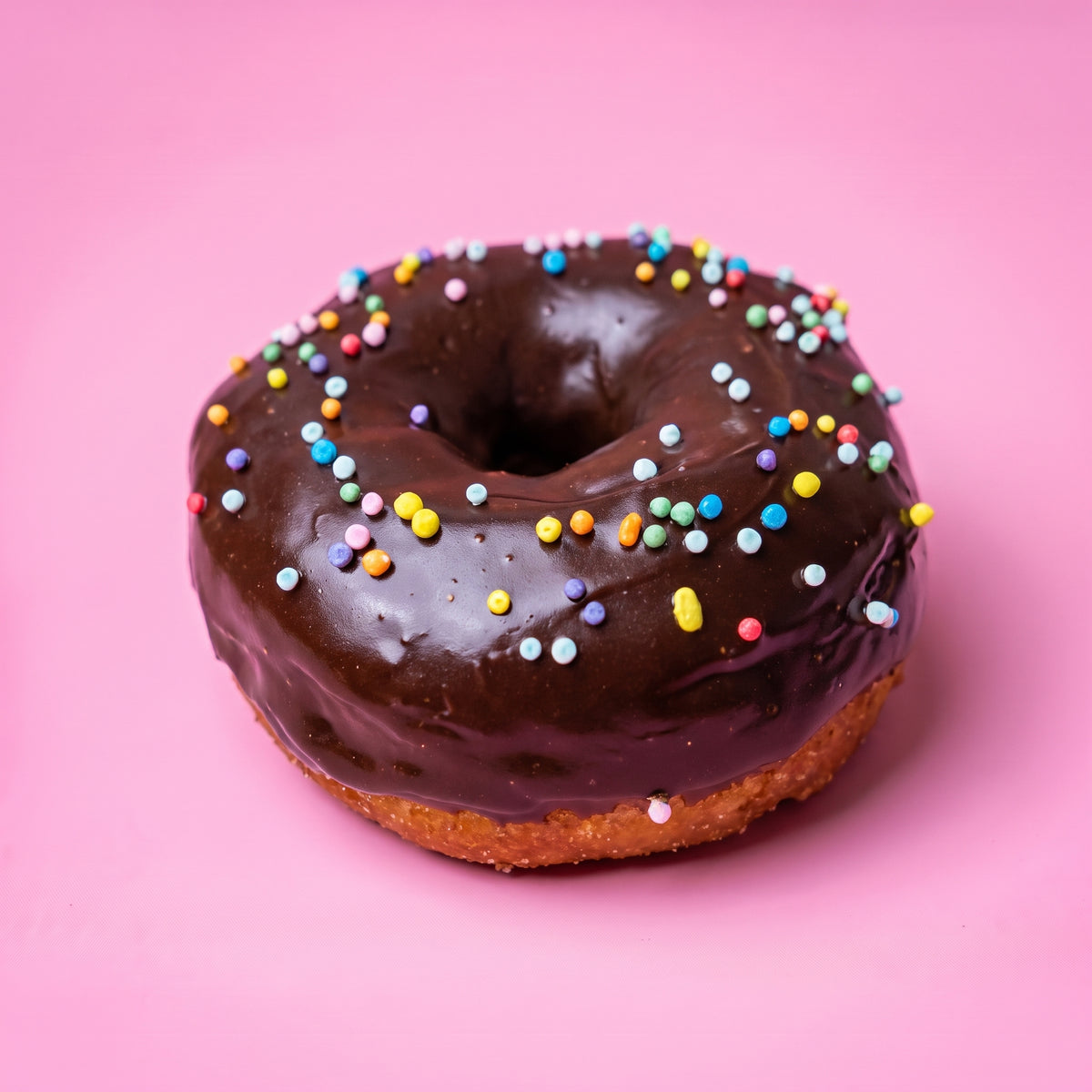 Gluten free vegan party doughnut with chocolate icing and rainbow sprinkles
