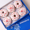 Gluten free vegan doughnuts with white icing, red heart sprinkles and Love toppers in a Borough 22 box
