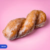 Gluten free vegan yum yum, a twisted doughnut baton under a glossy vanilla glaze